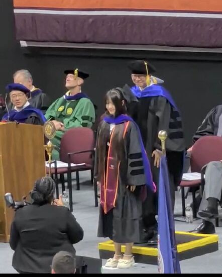 PhD hooding ceremony on stage